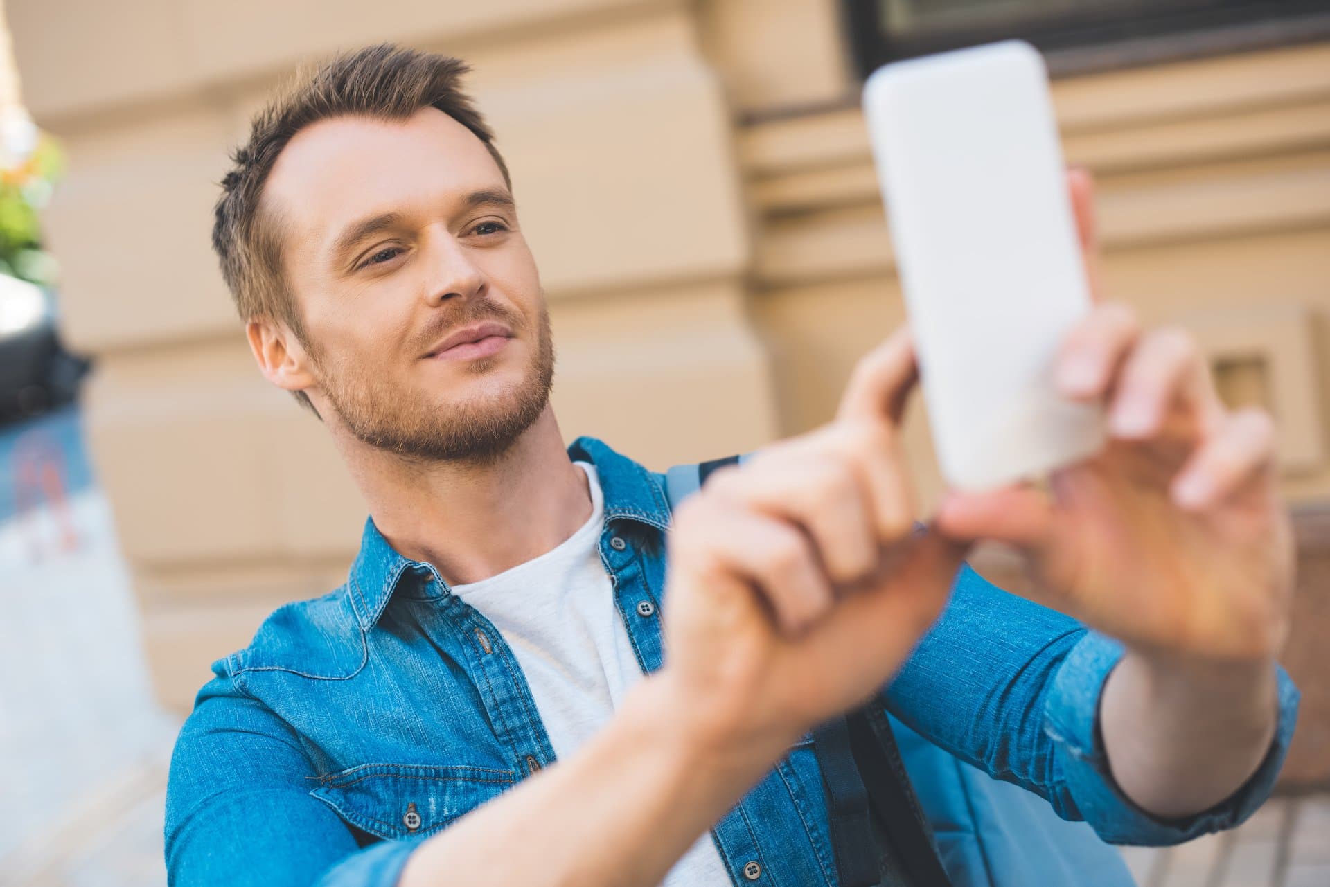 a man uses a smartphone to take a photo